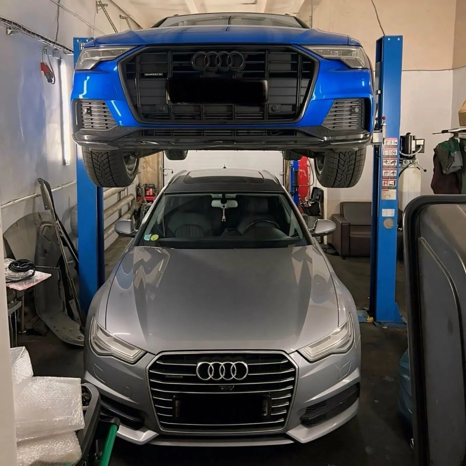 Audi Q7 на подъёмнике над Audi A6 в цеху Vag Group